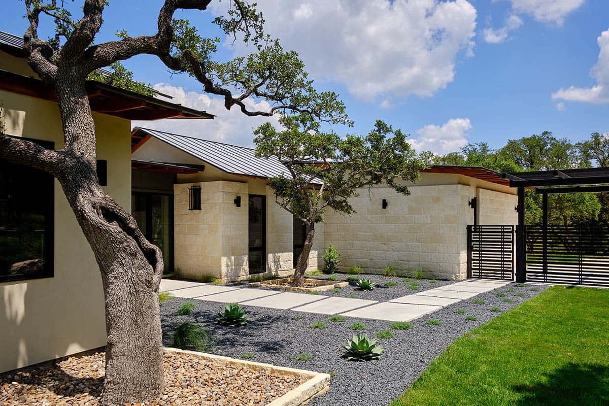 modern home with a stone exterior, a metal roof, and a landscaped front yard
