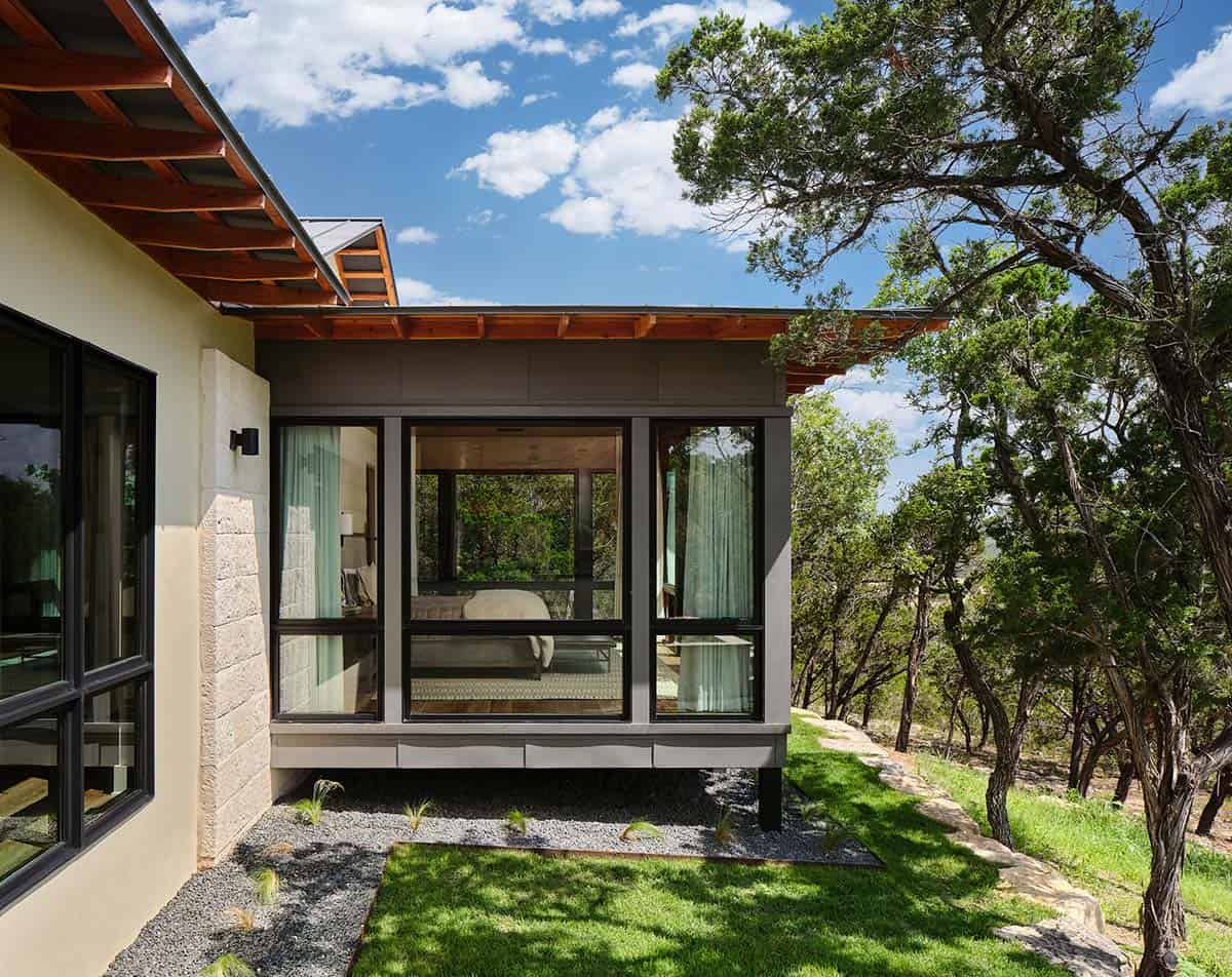 an outdoor view of a contemporary bedroom with large windows