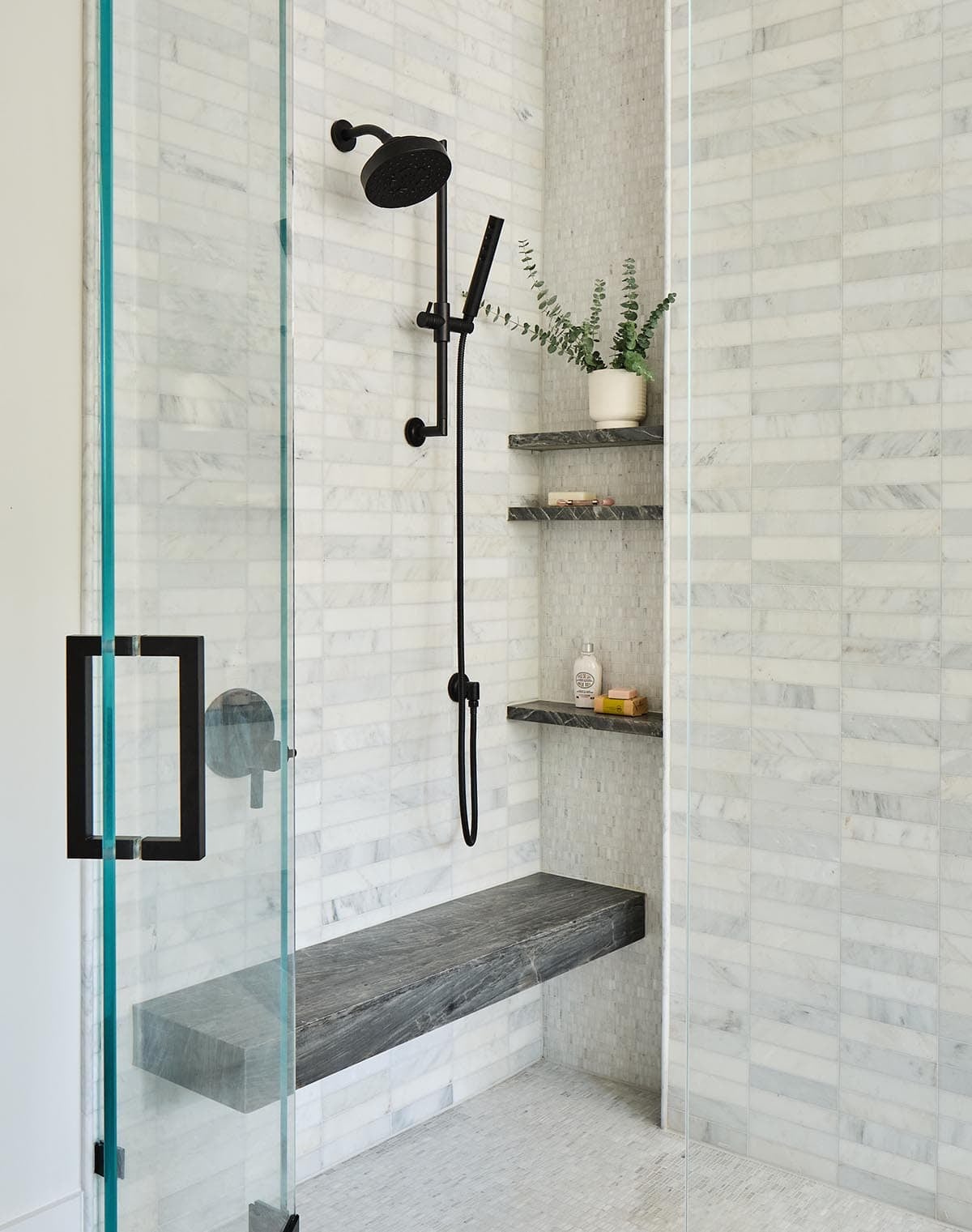modern shower with marble tiles and a black shower system
