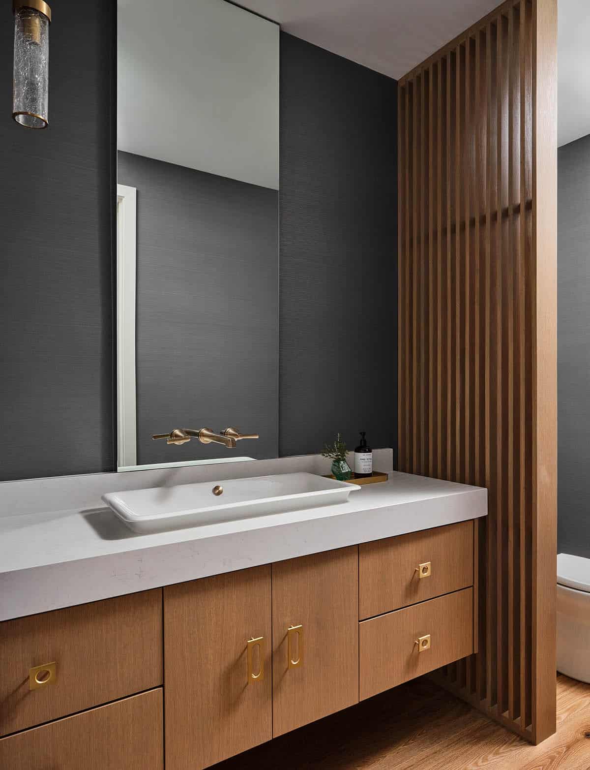 modern bathroom with a floating wood vanity, a white countertop, and a rectangular mirror