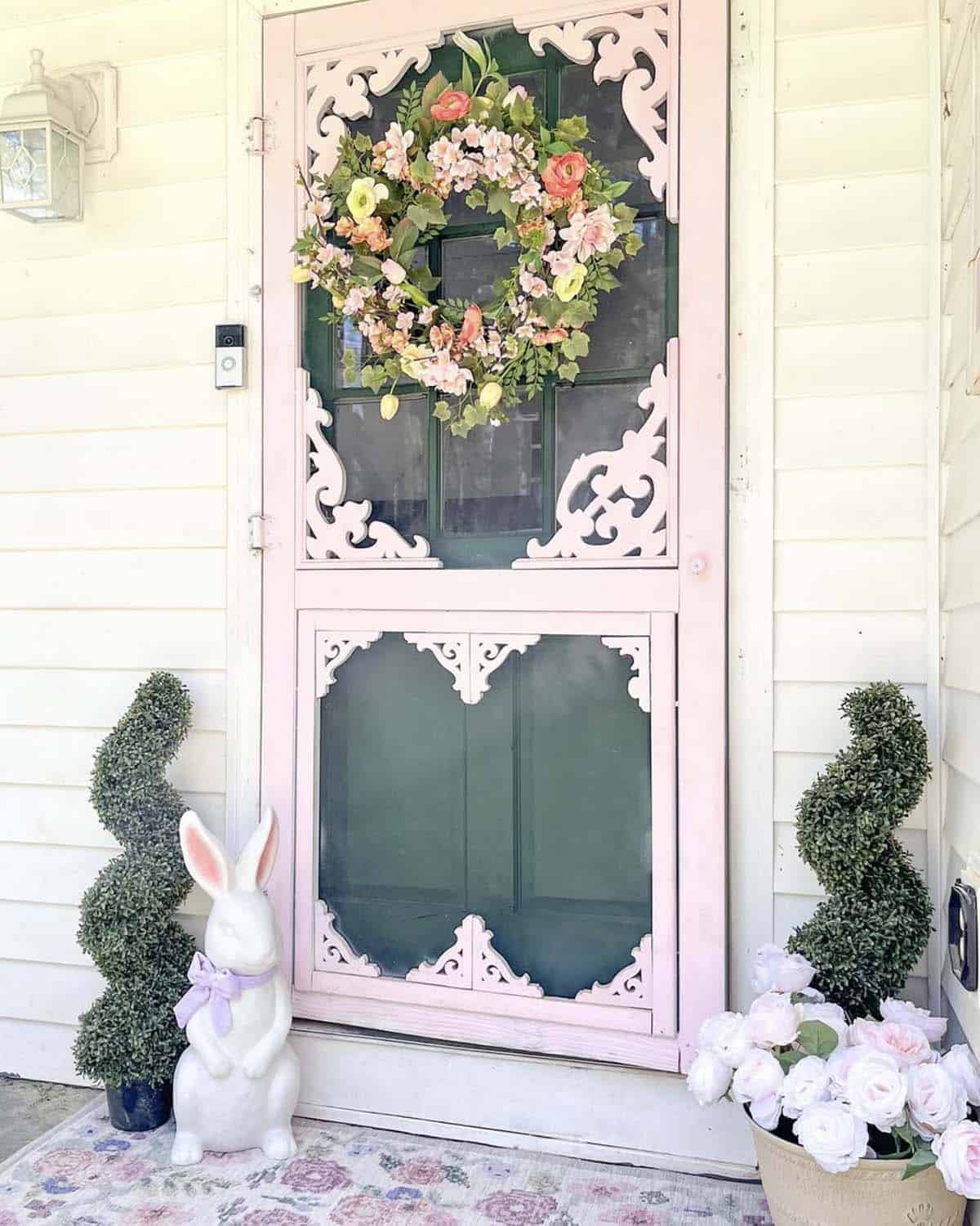 front porch spring refresh with topiaries and a pink door