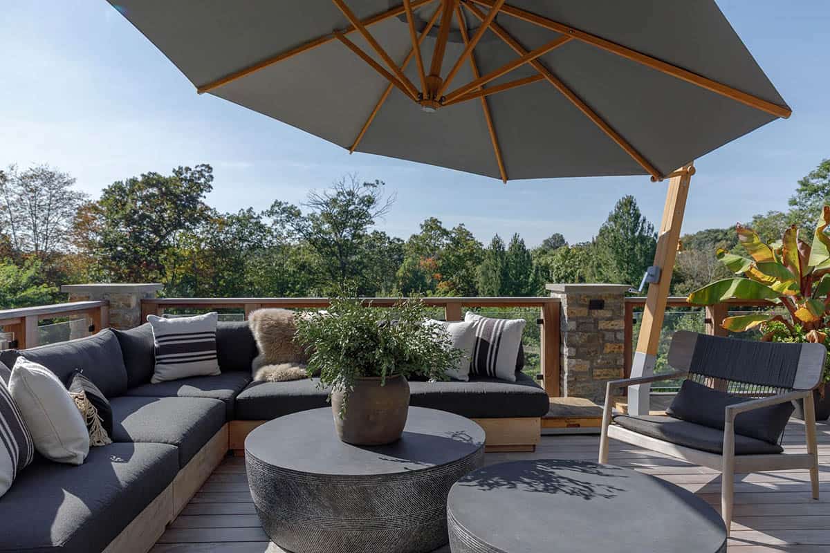 rustic modern barn house exterior patio with outdoor furniture and an umbrella