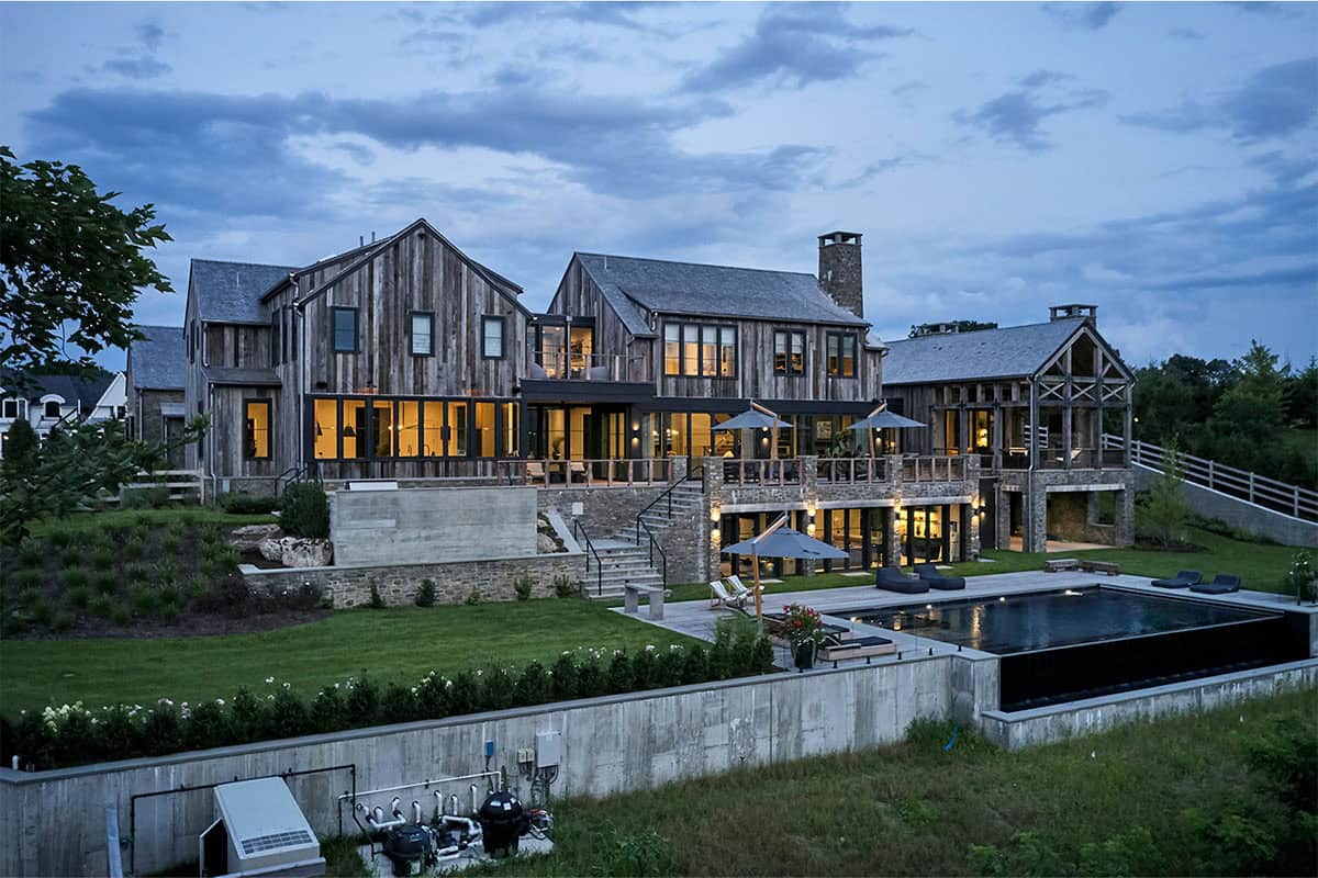 rustic modern barn house exterior backyard view at dusk