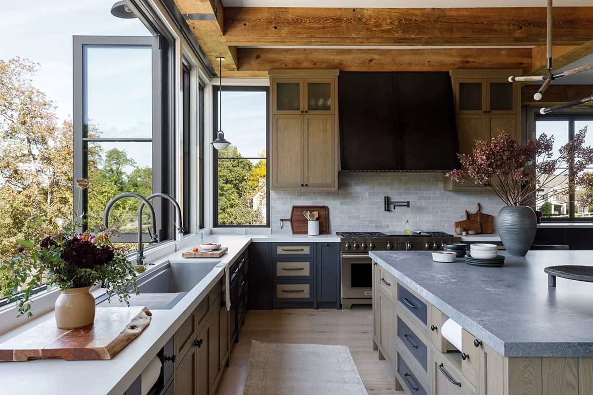 rustic modern kitchen with a large range hood and windows