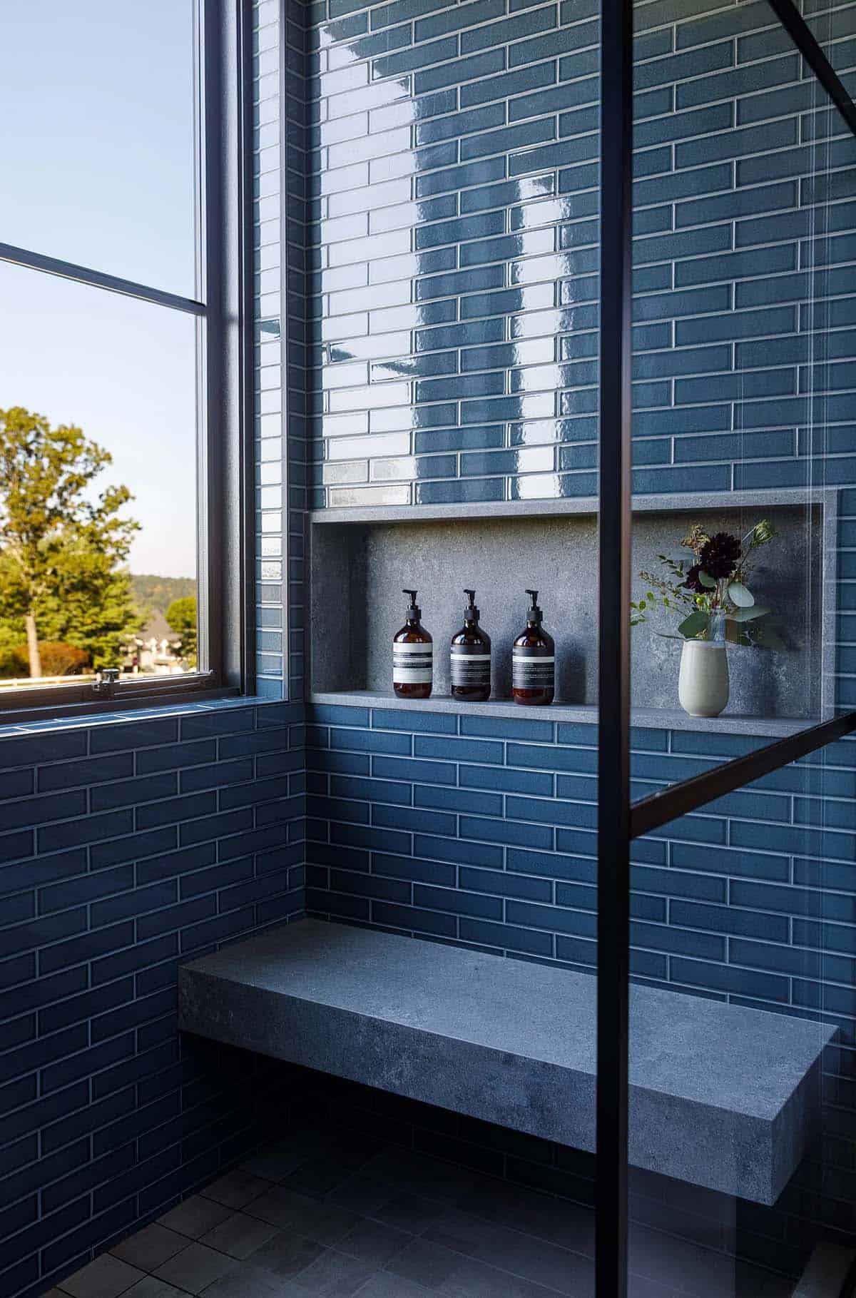 rustic modern bathroom shower with blue tiles and a niche