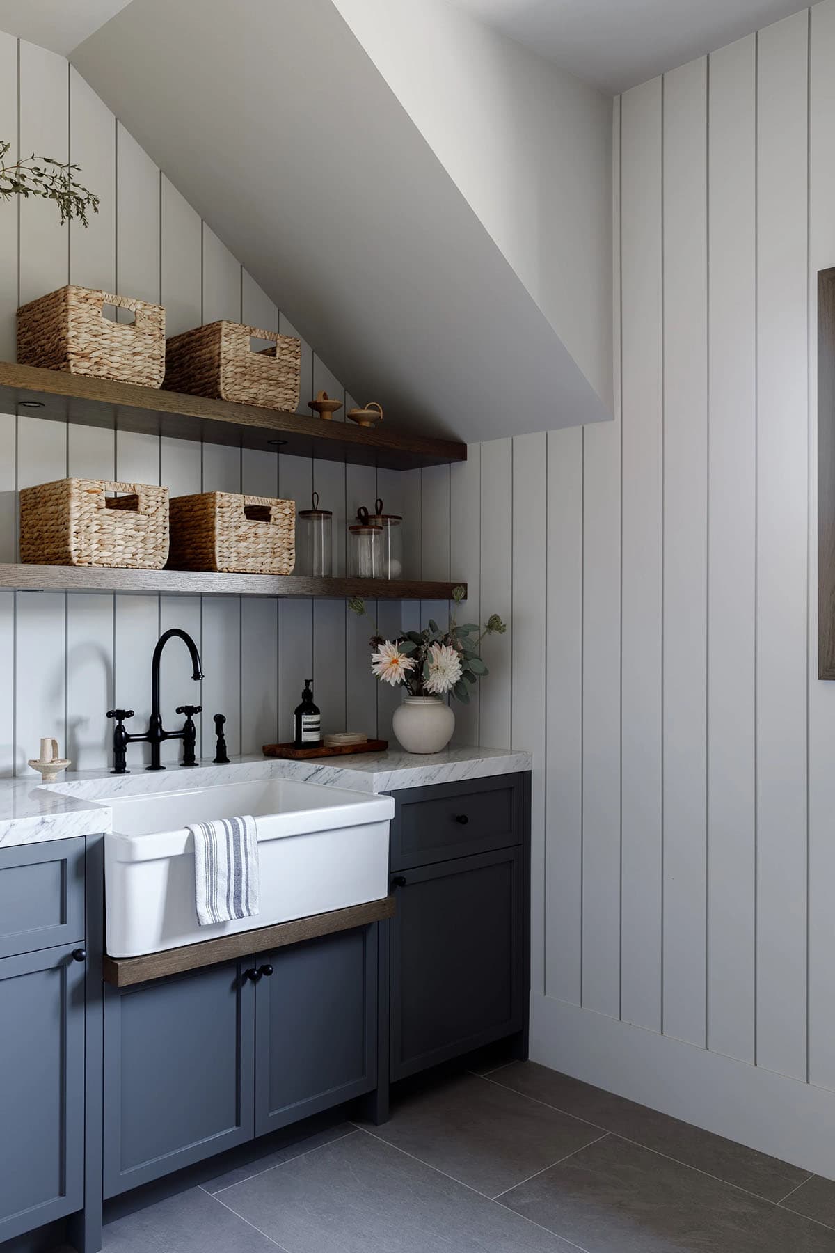 rustic modern laundry room with a sink and floating shelves