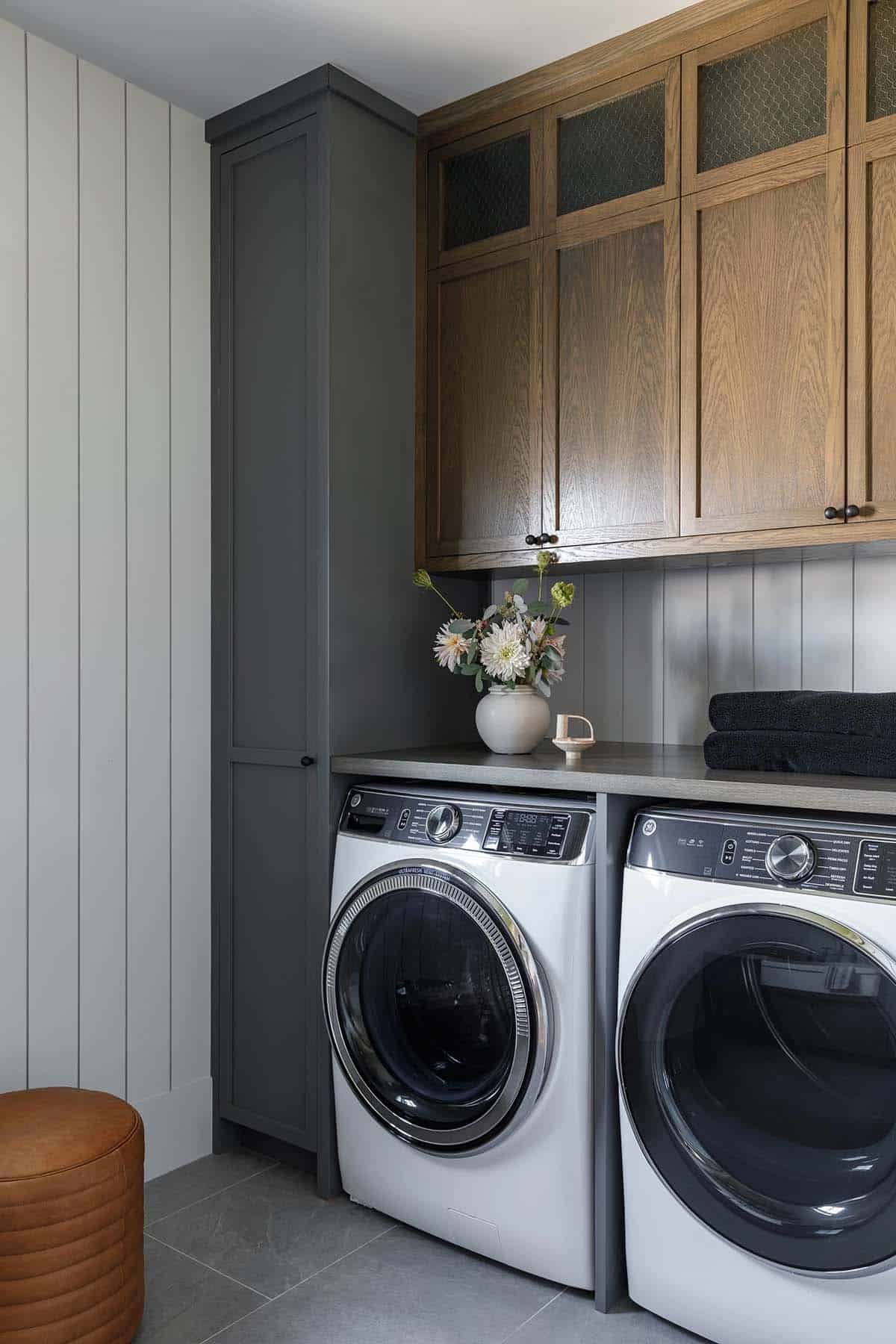 rustic modern laundry room with a washer and dryer and upper cabinet