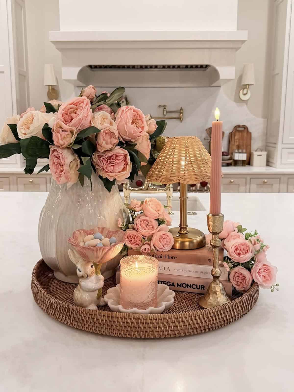 Spring kitchen island tray styling with blush garden roses, rattan lamp, pink taper candle, and bunny figurine