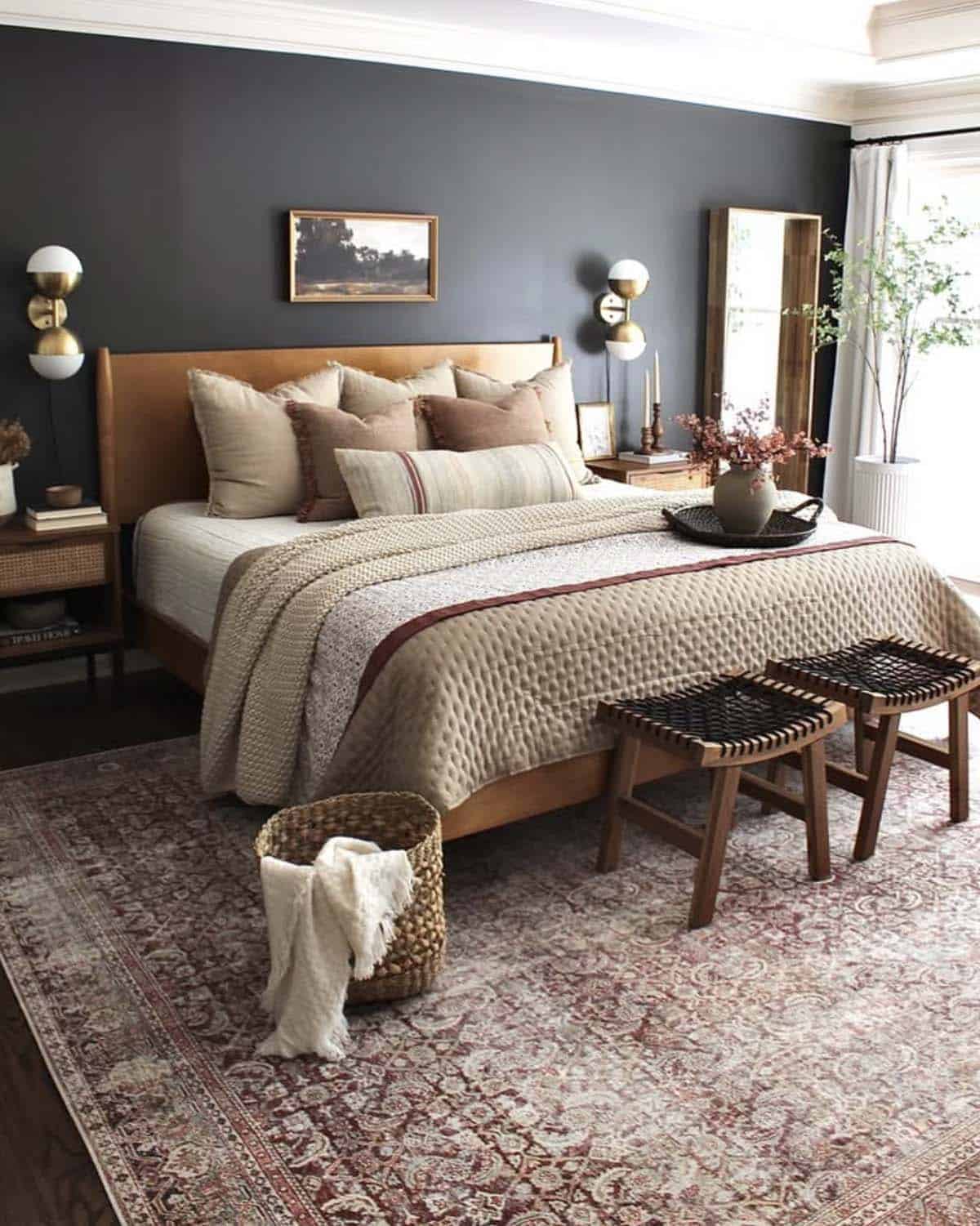 Moody bedroom with dark charcoal accent wall, warm walnut bed, and rust Persian rug