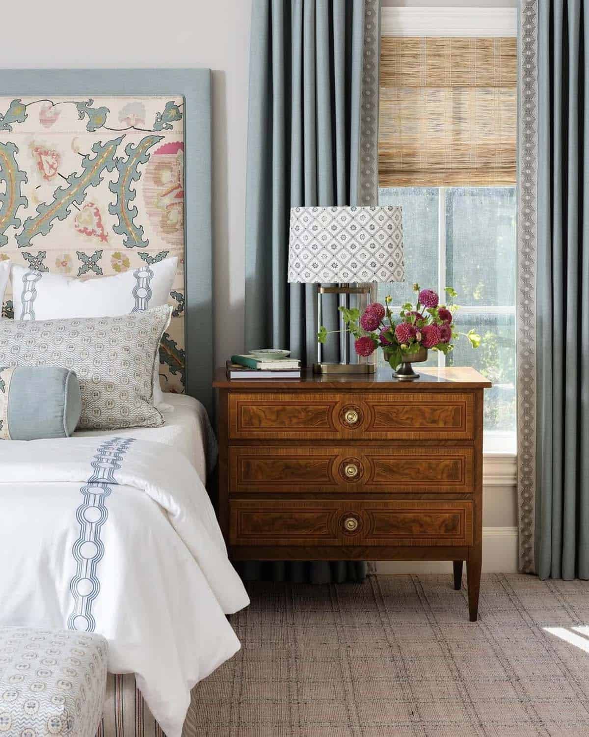 2 / 2Warm spring bedroom with wicker dome lamp, gingham upholstered bed and floral linen curtains