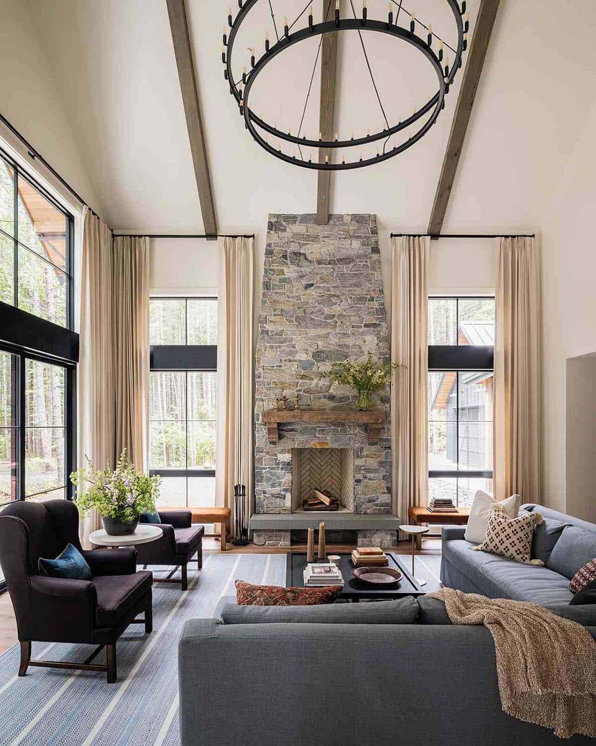 Vaulted living room with floor-to-ceiling stone fireplace, exposed wood beams, and ring chandelier, Greenwater, Washington