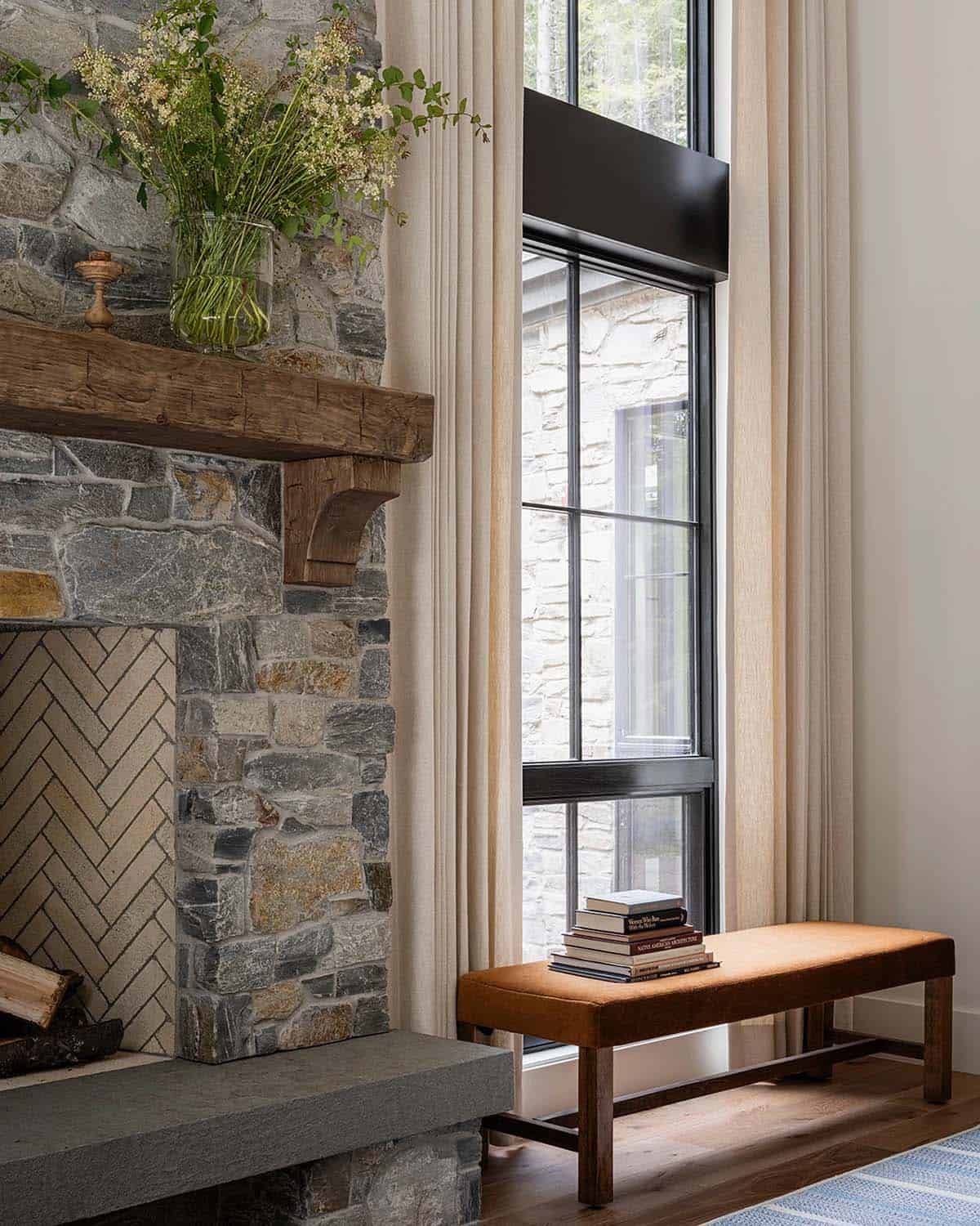 Close-up of stone fireplace surround with reclaimed wood mantle and leather window bench, Mt. Rainier cabin