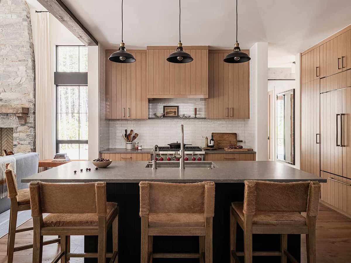 Kitchen with planked oak cabinetry, black island, stone countertops, and cowhide bar stools, alpine cabin near Mt. Rainier