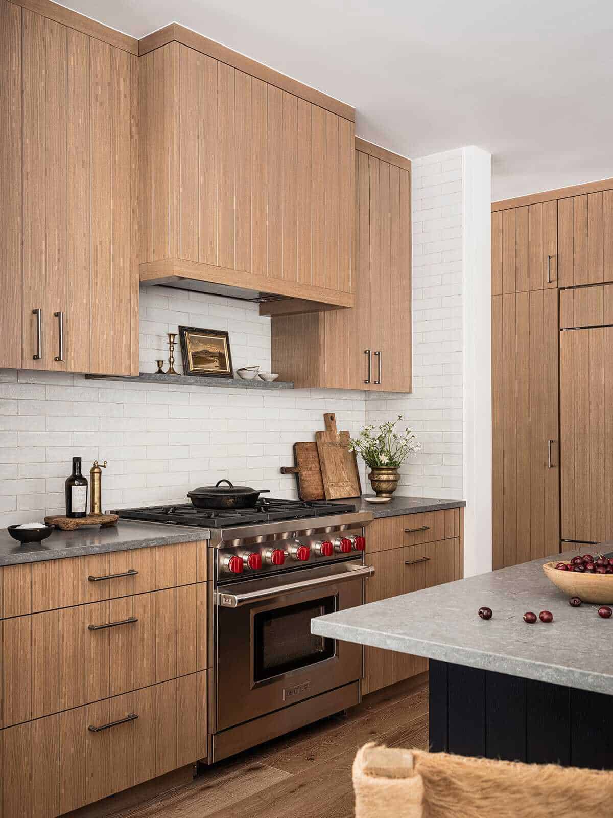 Kitchen with planked oak cabinetry, Wolf range, white tile backsplash, and stone countertops, alpine cabin near Mt. Rainier
