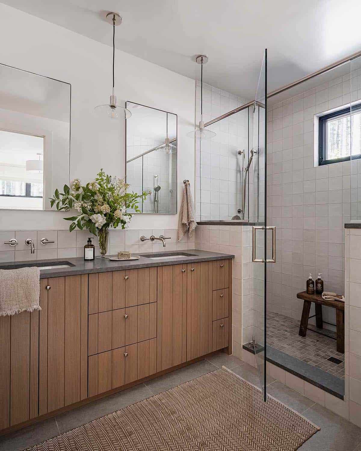 Primary bathroom with oak vanity, stone countertop, glass shower, and pendant lights, alpine cabin near Mt. Rainier