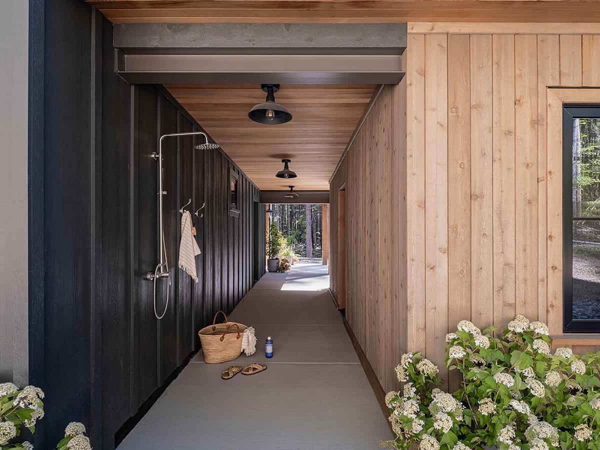 Covered breezeway with outdoor shower, cedar paneling, and black pendant lights, alpine cabin near Mt. Rainier