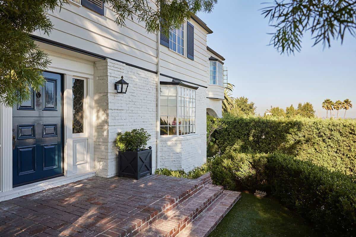 Colonial Revival home exterior with white brick, navy blue door, and brick pathway, Los Feliz, California