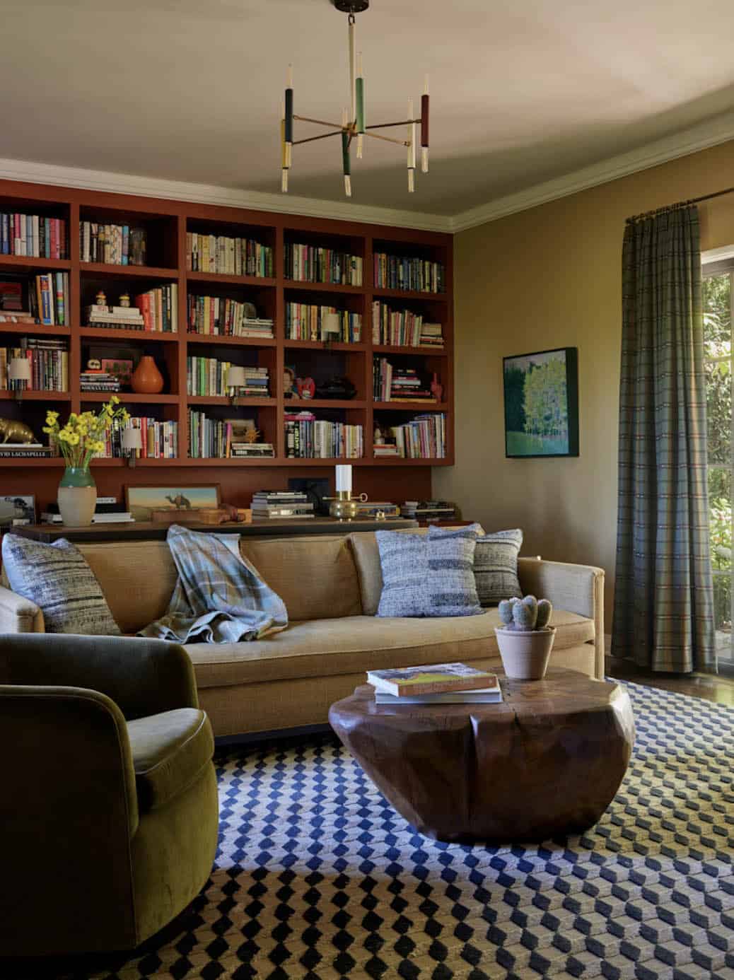 Library with terracotta built-in bookshelves and wood stump coffee table, Los Feliz colonial revival home