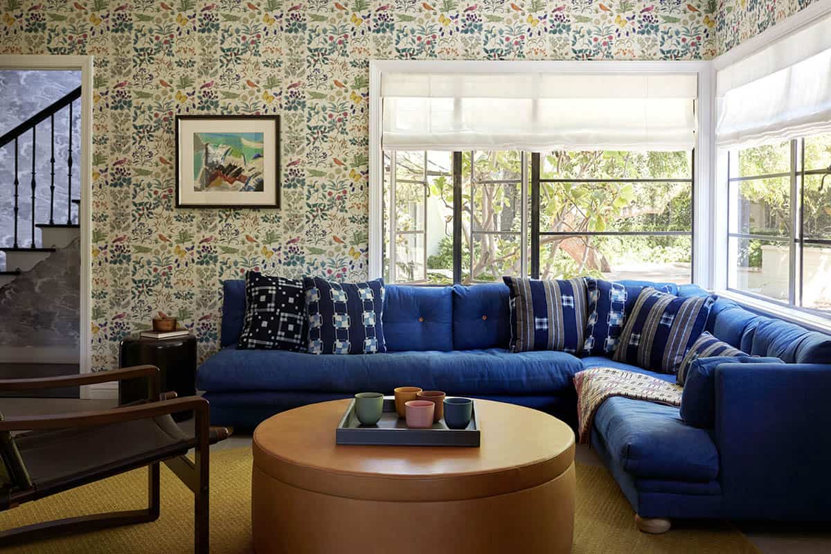 Family room with blue sectional sofa and colorful bird and botanical wallpaper, Los Feliz colonial revival home