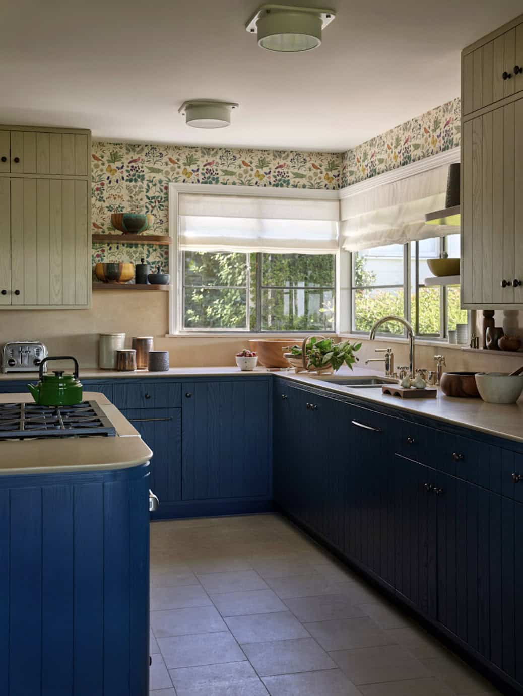 Kitchen with navy lower cabinets, sage upper cabinets, and botanical wallpaper, Los Feliz colonial revival home