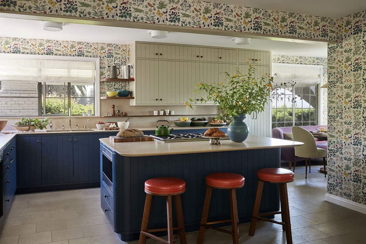 Kitchen with navy island, red leather stools, and botanical wallpaper, Los Feliz colonial revival home