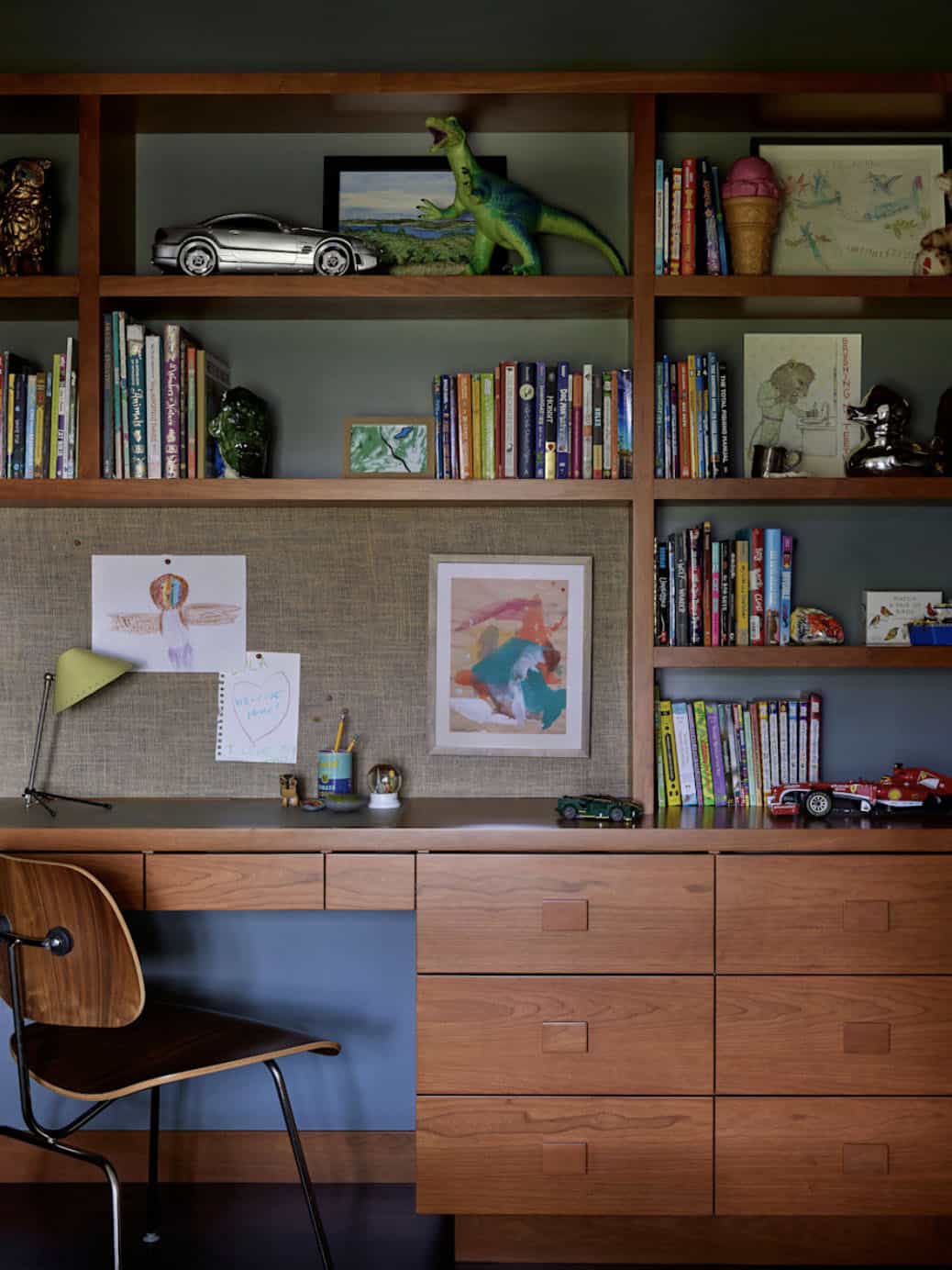 Built-in walnut bookcase with desk, linen pinboard, and Eames chair in children's room, Colonial Revival home by Commune Design, Los Feliz