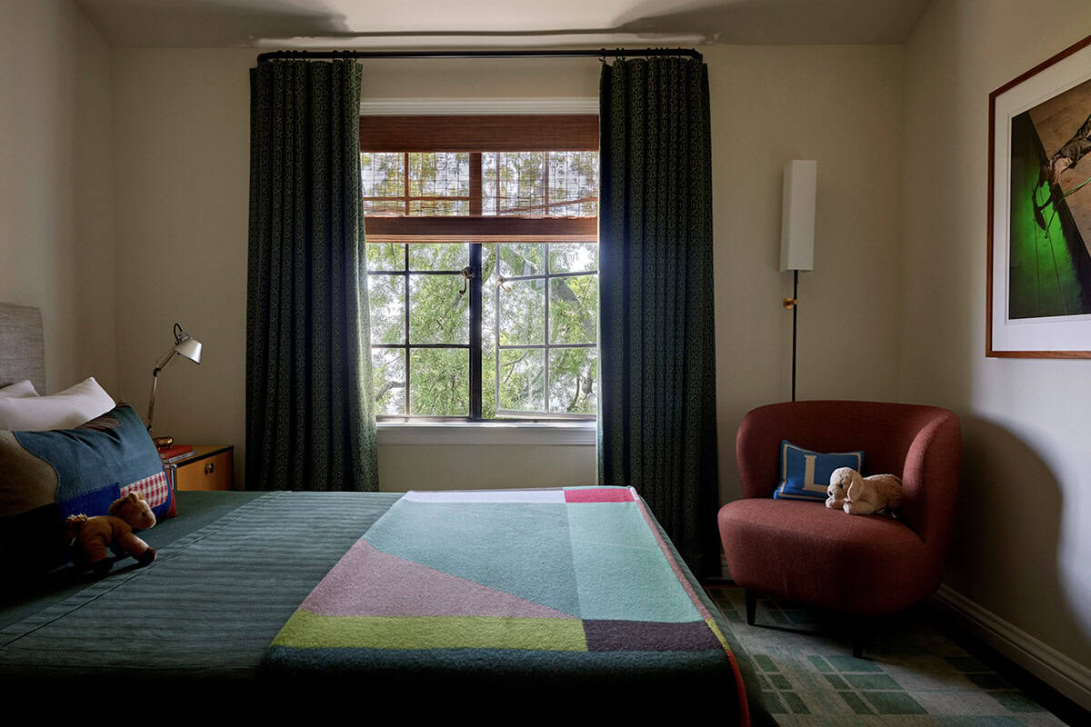Children's bedroom with colorful patchwork bedding, green patterned curtains, and red lounge chair, Los Feliz, California