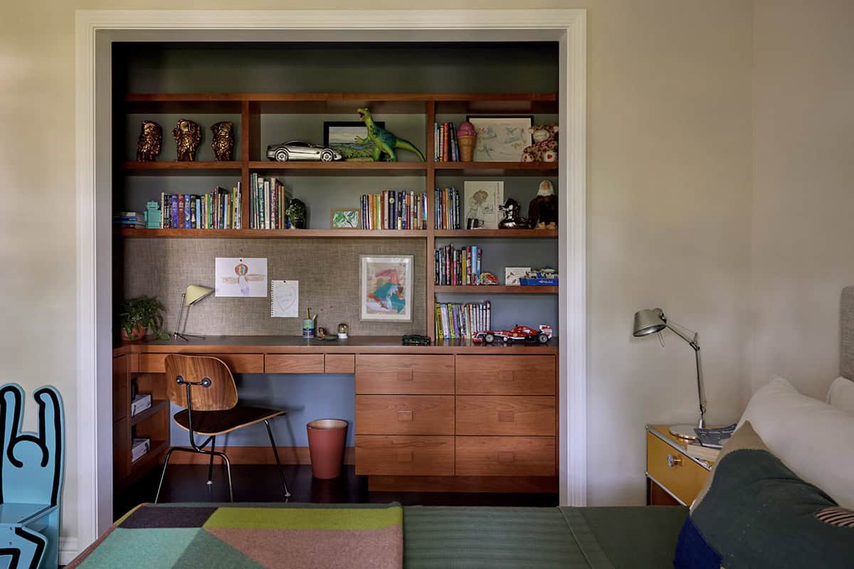 Built-in walnut bookcase with integrated desk niche and Eames chair, children's room, Colonial Revival home by Commune Design