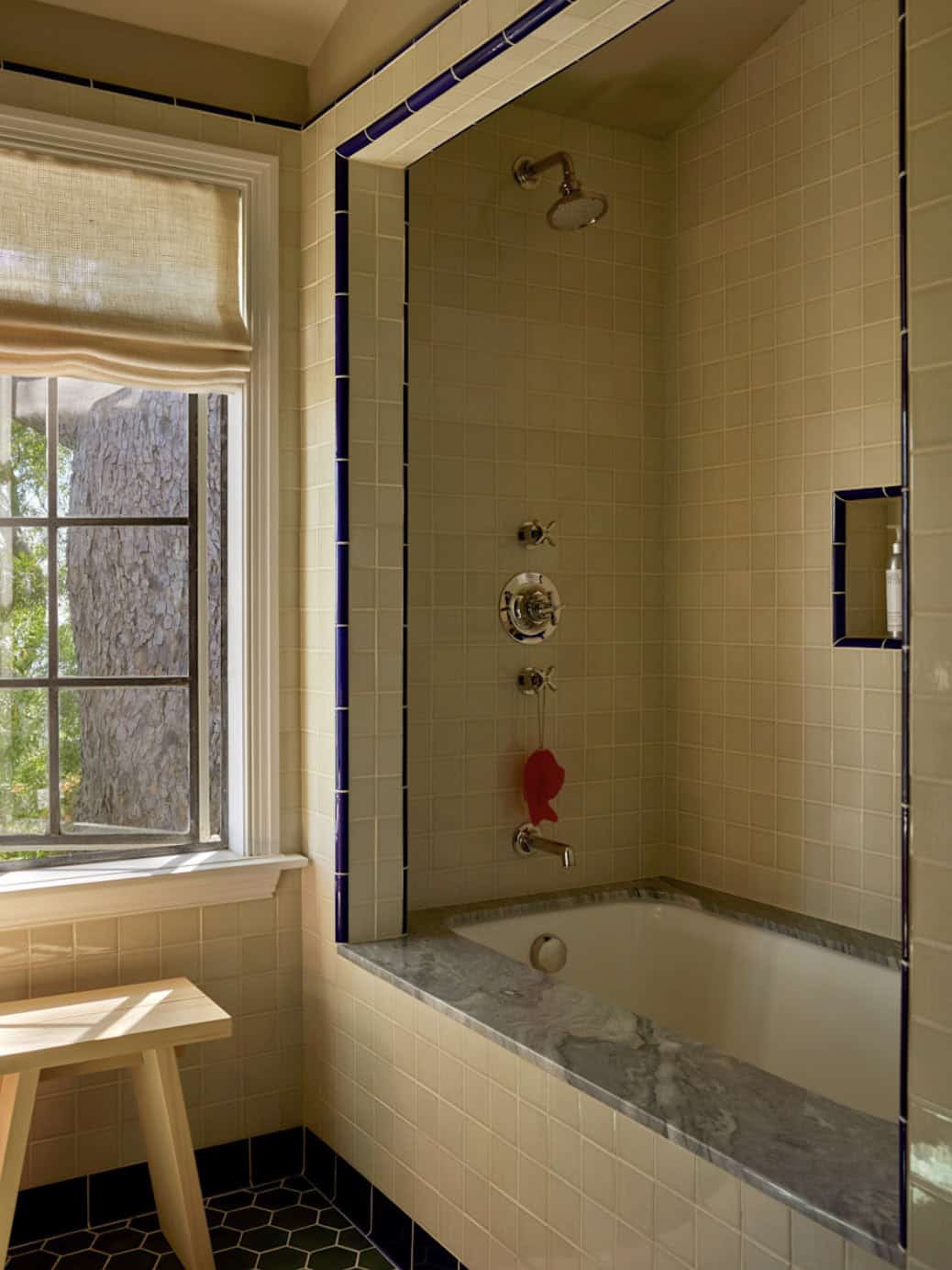 Bathroom with cream subway tile, cobalt blue trim, marble tub surround, and hexagon floor tile, Los Feliz home by Commune Design