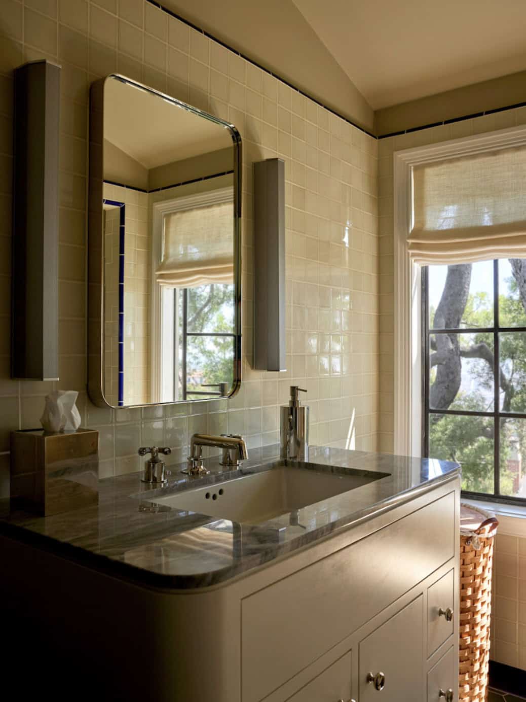 Bathroom vanity with marble countertop, polished nickel faucet, and cream tile walls with cobalt accent, Los Feliz, California