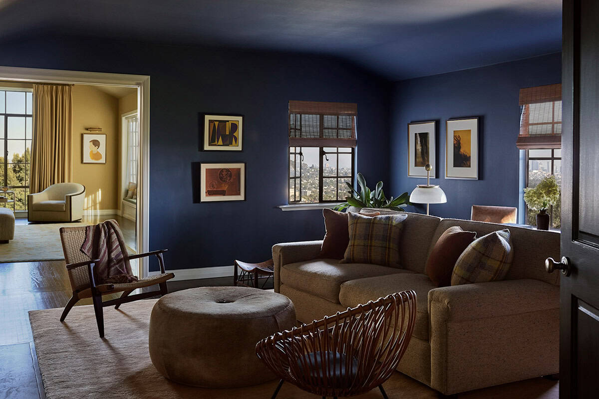 Navy blue den with vintage sofa, woven lounge chair, art collection, and city views, Colonial Revival home by Commune Design