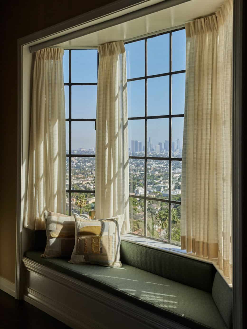 Window seat with linen cushion and panoramic Los Angeles skyline views, Colonial Revival home in Los Feliz, California