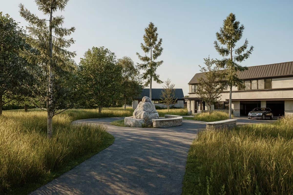Circular driveway with stone sculpture and natural grass landscape at Nature's Edge contemporary home in Hudson Wisconsin