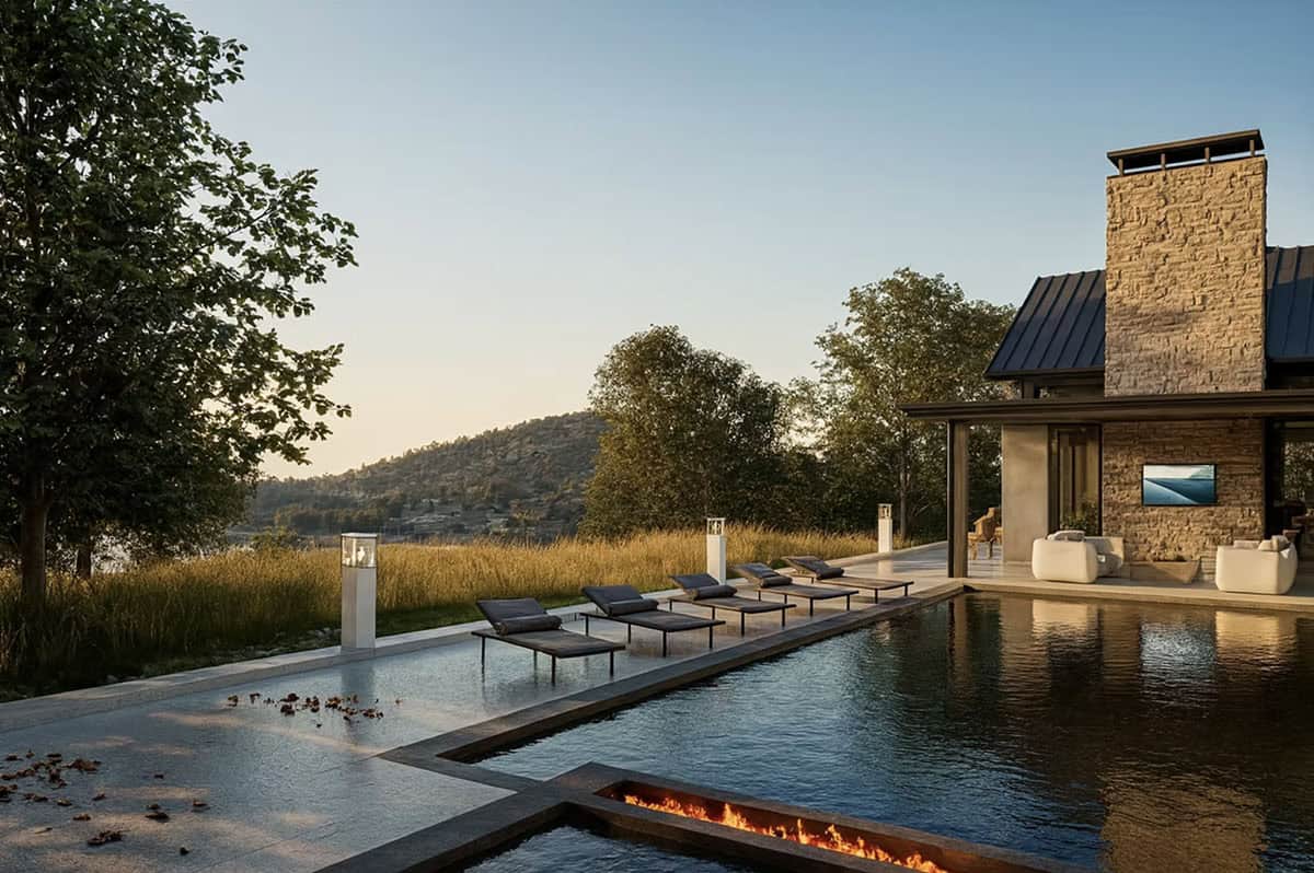 Outdoor pool and fire feature with lounge chairs overlooking St. Croix River at Nature's Edge home in Hudson Wisconsin