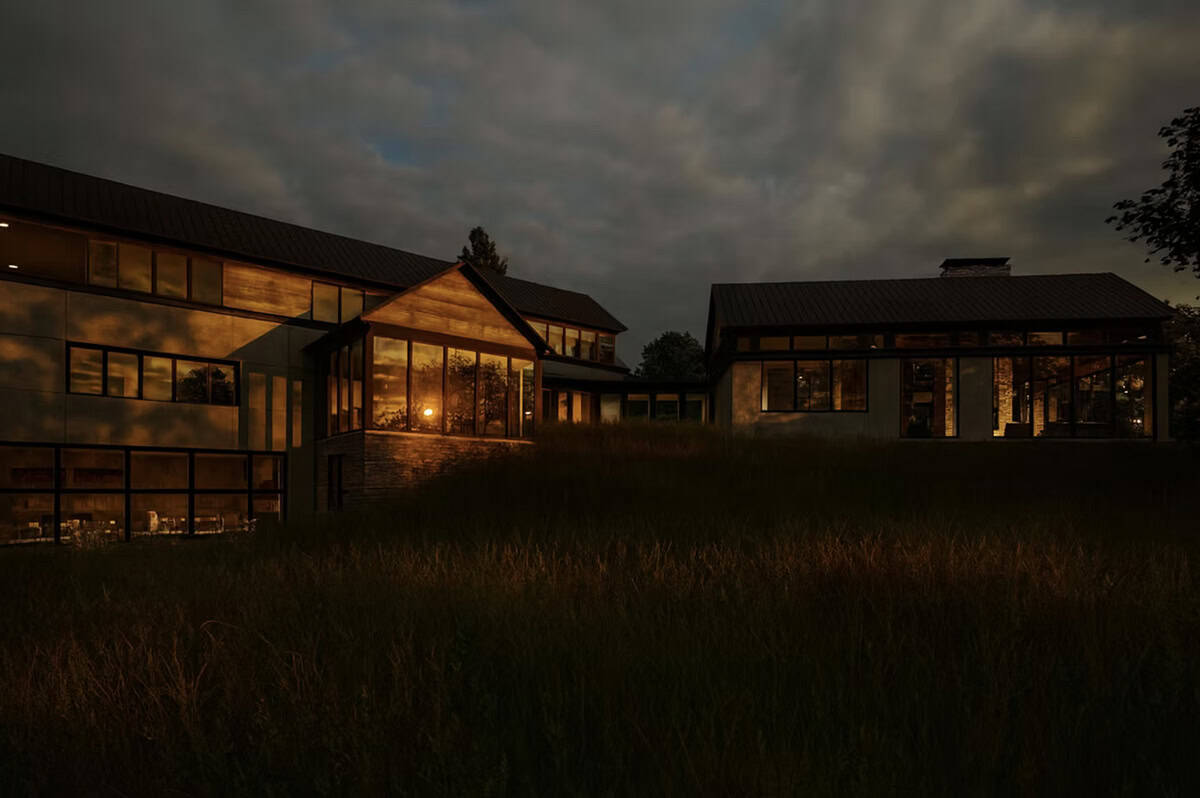 Contemporary home exterior at night with warm interior lighting glowing through floor-to-ceiling windows in Hudson Wisconsin