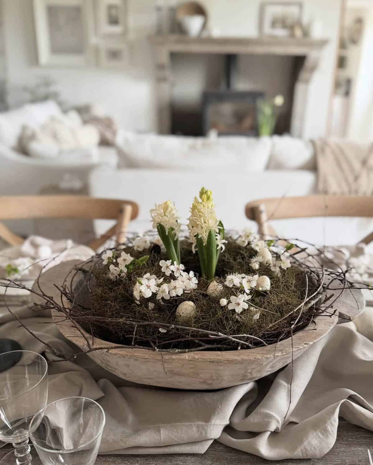 Easter dough bowl centerpiece with white hyacinths, moss, cherry blossoms, and speckled quail eggs