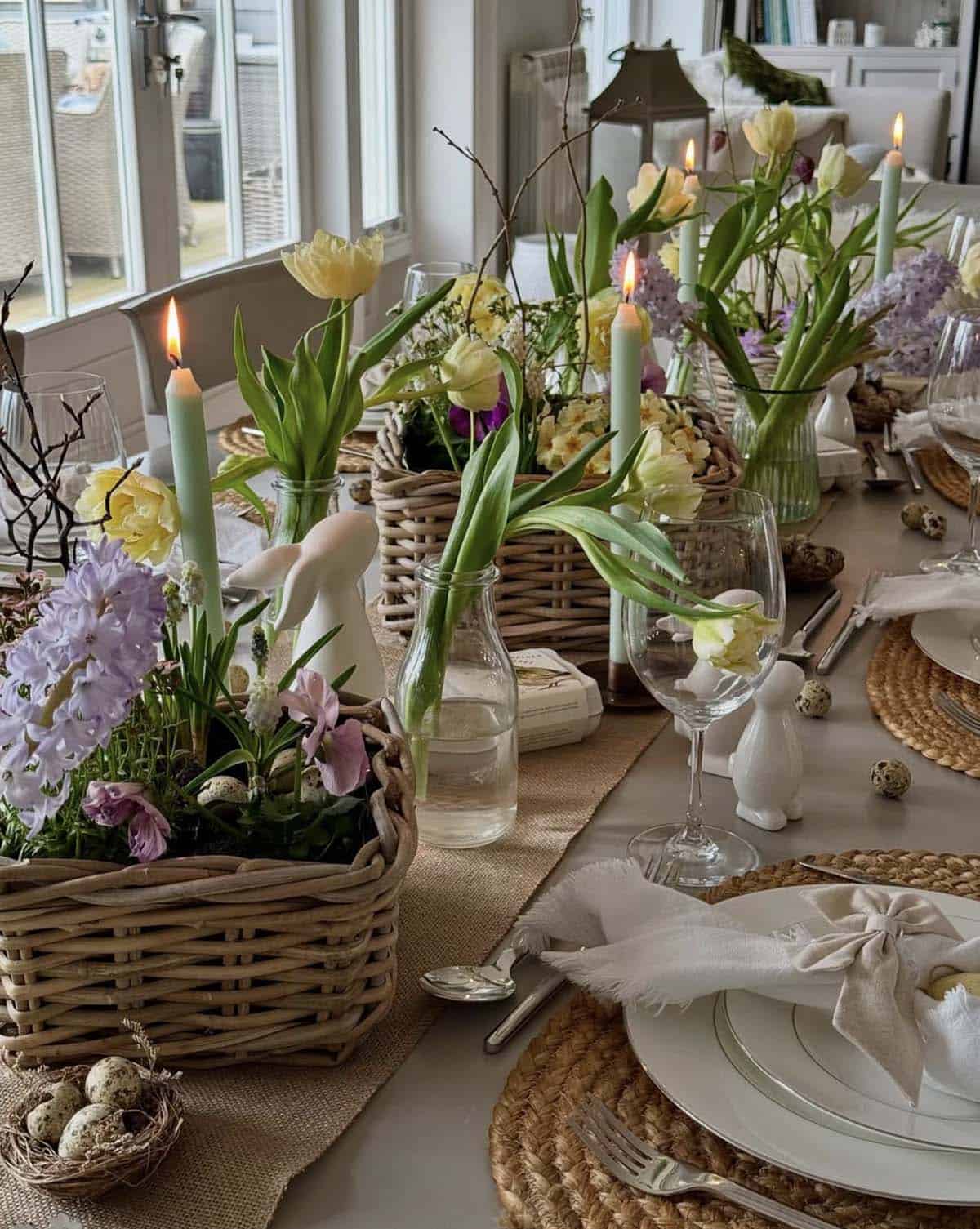 Easter tablescape with wicker basket centerpieces filled with tulips, hyacinths, and mint green taper candles