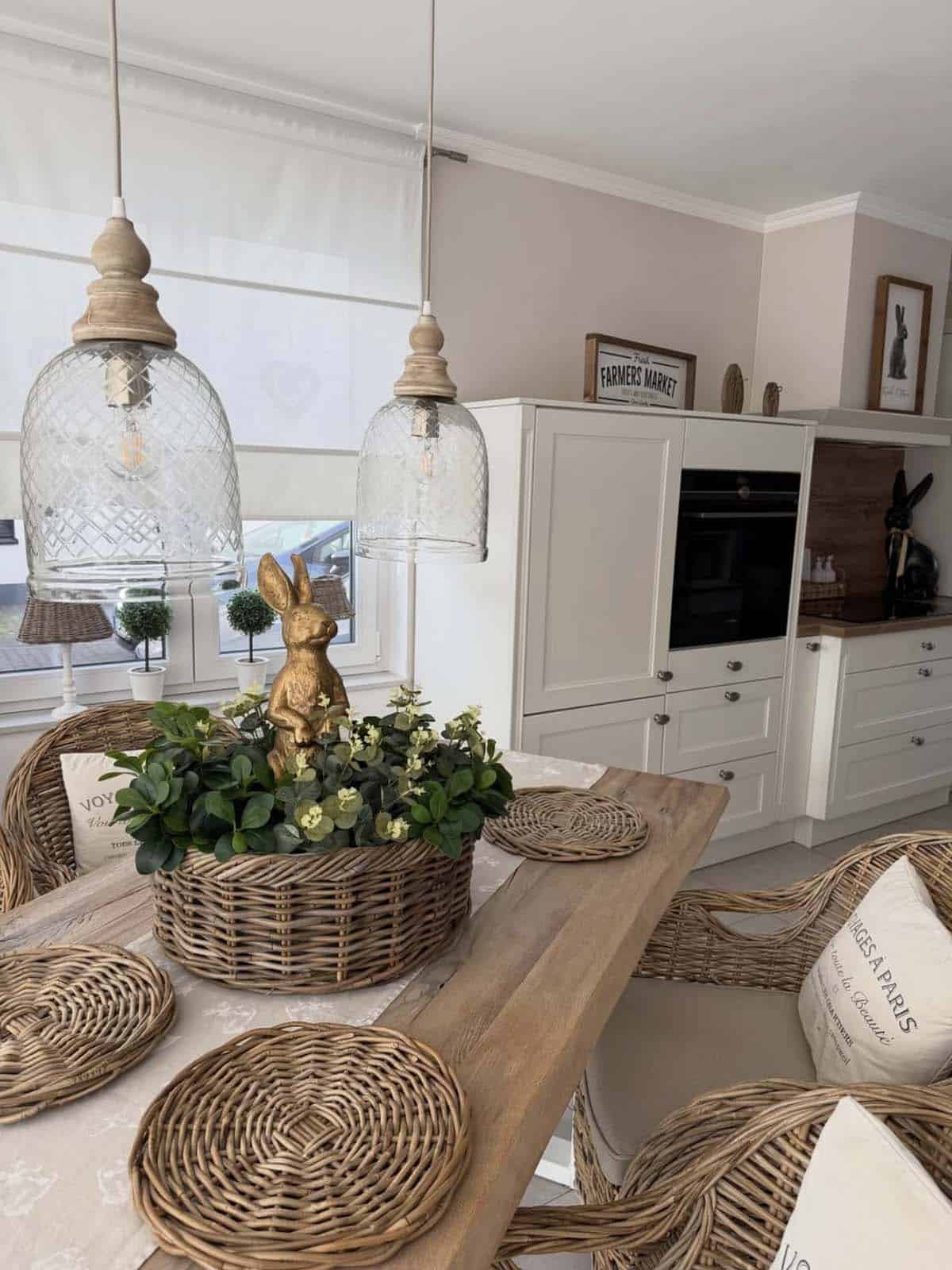 Easter table decor with gold bunny centerpiece, eucalyptus greenery, and wicker placemats