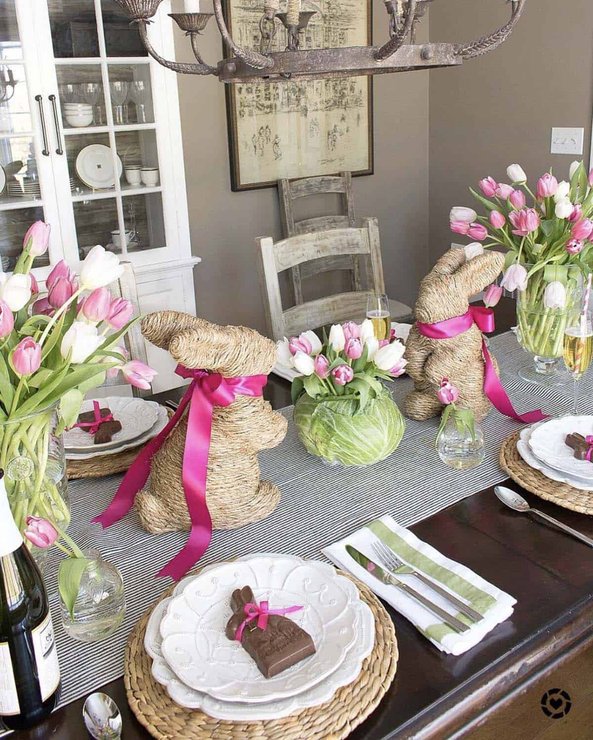Creative Easter table with cabbage centerpiece, pink and white tulips, and chocolate bunny place settings