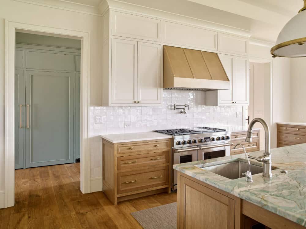 White kitchen with white oak cabinets and range hood in Maryland Eastern Shore waterfront home