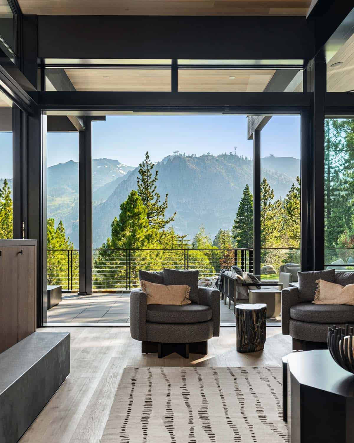Living room with open glass walls and panoramic mountain views