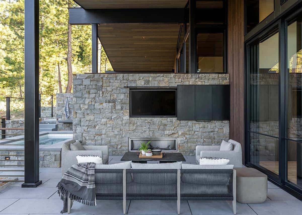 Covered outdoor lounge with stone fireplace wall and plunge pool