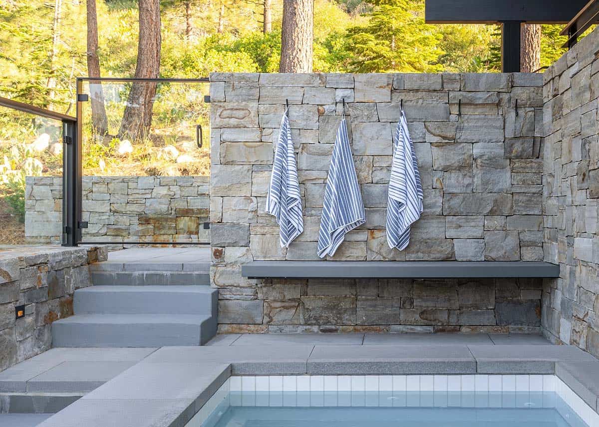 Outdoor spa area with stacked stone walls and concrete bench