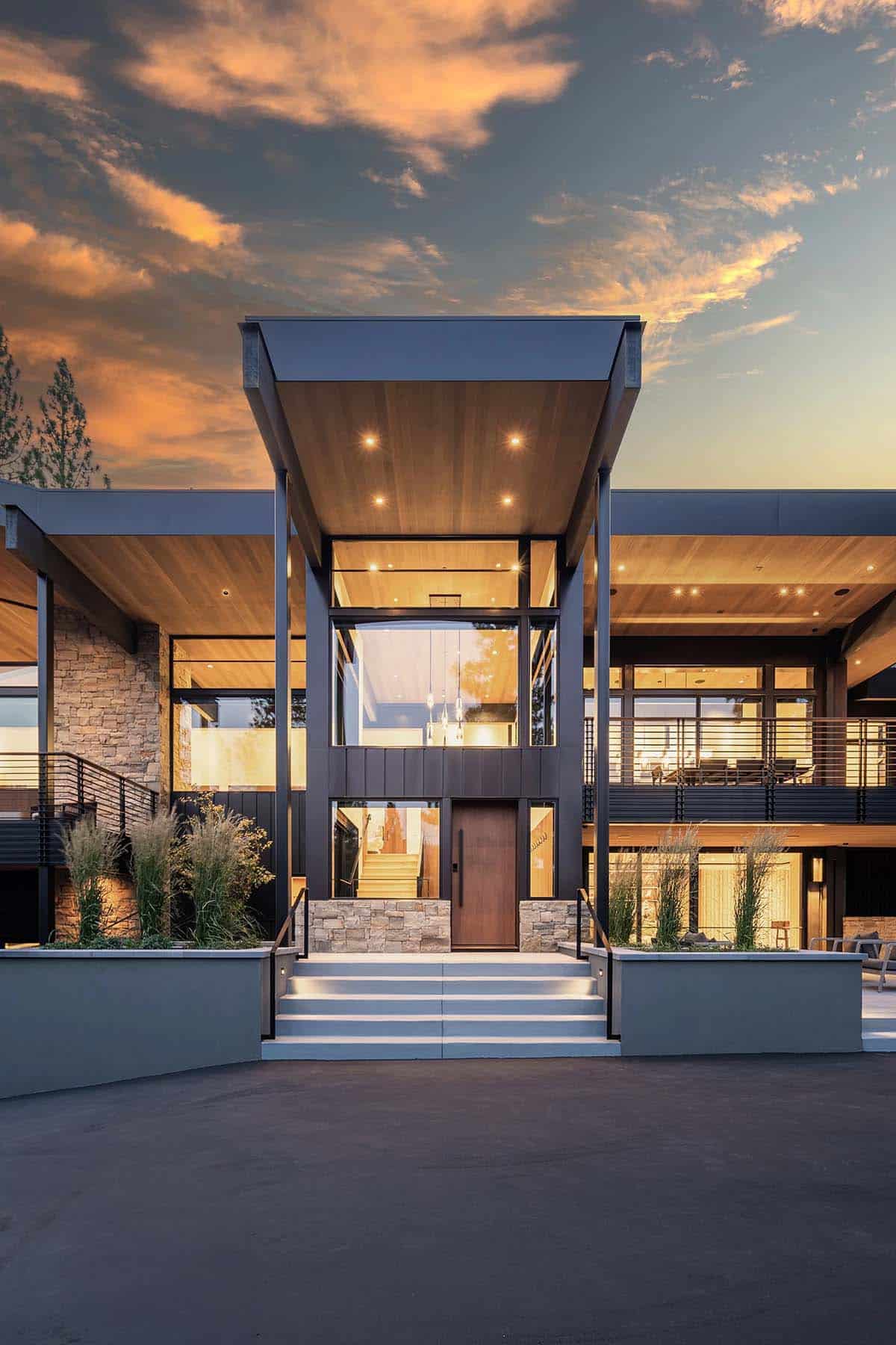 Symmetrical front entrance at twilight with cantilevered canopy and wood ceiling lighting