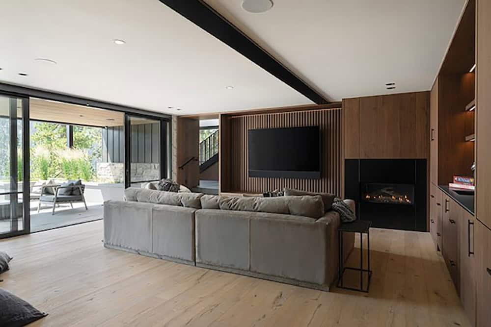 lower-level media room with a fireplace and tv 