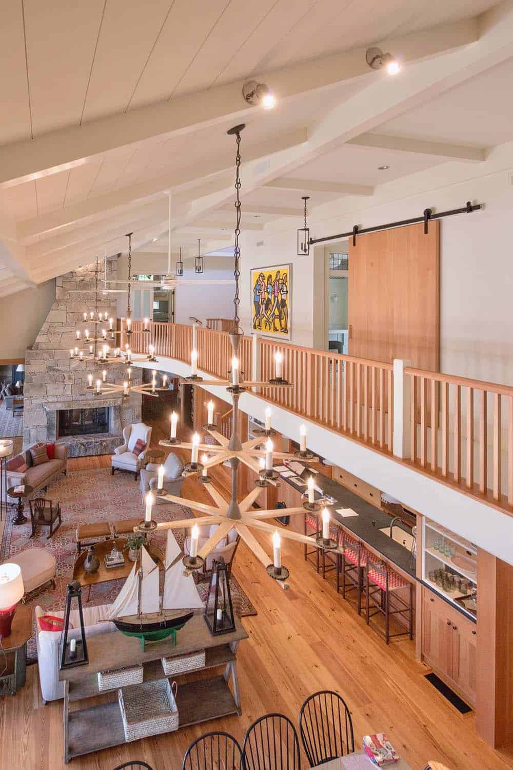 Interior great room of the classic New England lake house with soaring ceiling, wood paneling, large multi-paned windows overlooking Lake Sunapee, and antique and vintage furnishings curated by Marc-Michaels designer Robin Sturm