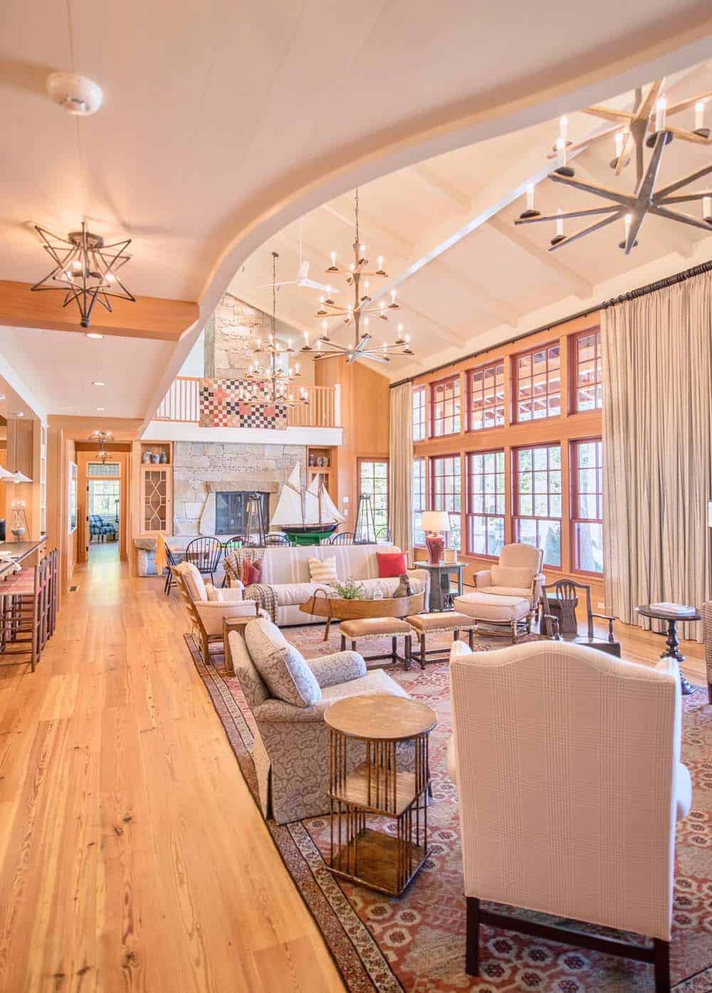 Great room interior detail showing warm traditional furnishings &mdash; antique and vintage pieces including upholstered sofas, woven rugs, and layered textiles creating a collected, nostalgic atmosphere on Lake Sunapee, New Hampshire