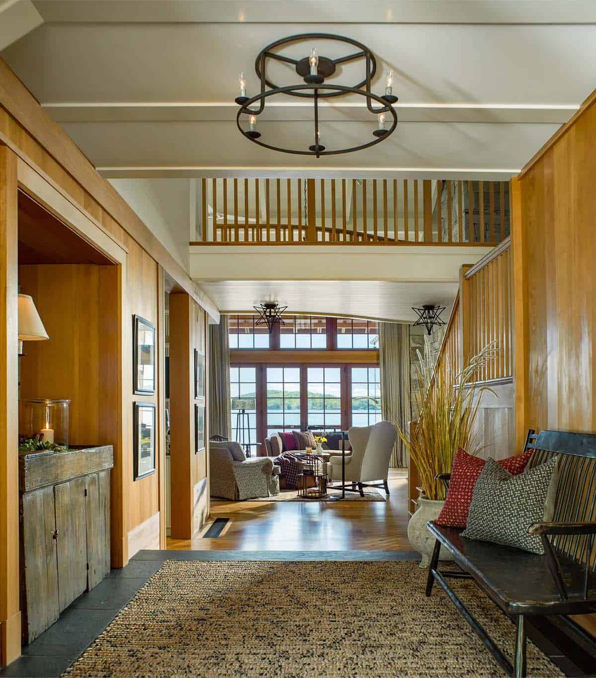 Interior hallway of the Lake Sunapee New Hampshire lake house &mdash; hardwood floors, painted wood paneling, and natural light at the end of the corridor guiding toward the bedroom wing