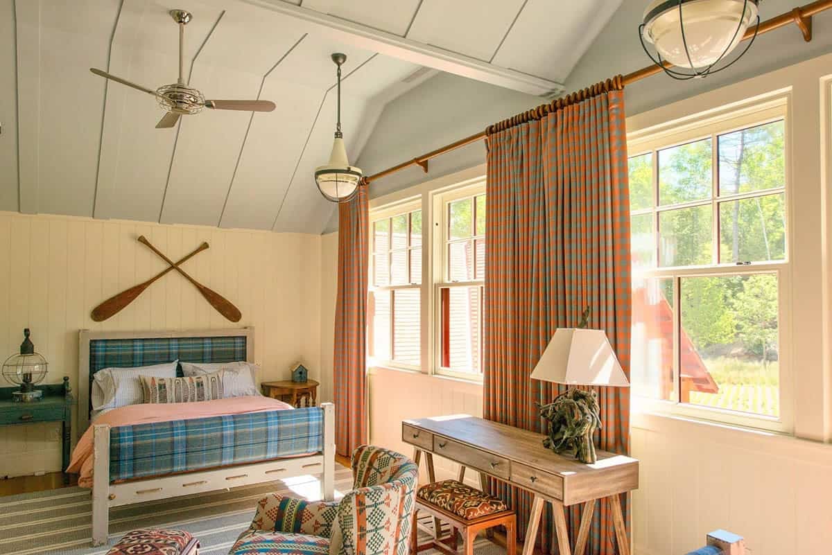 Primary bedroom of the Lake Sunapee New Hampshire lake house &mdash; a custom bed from Mark Jupiter, plaid accents, neutral palette, and lake-facing windows providing natural morning light