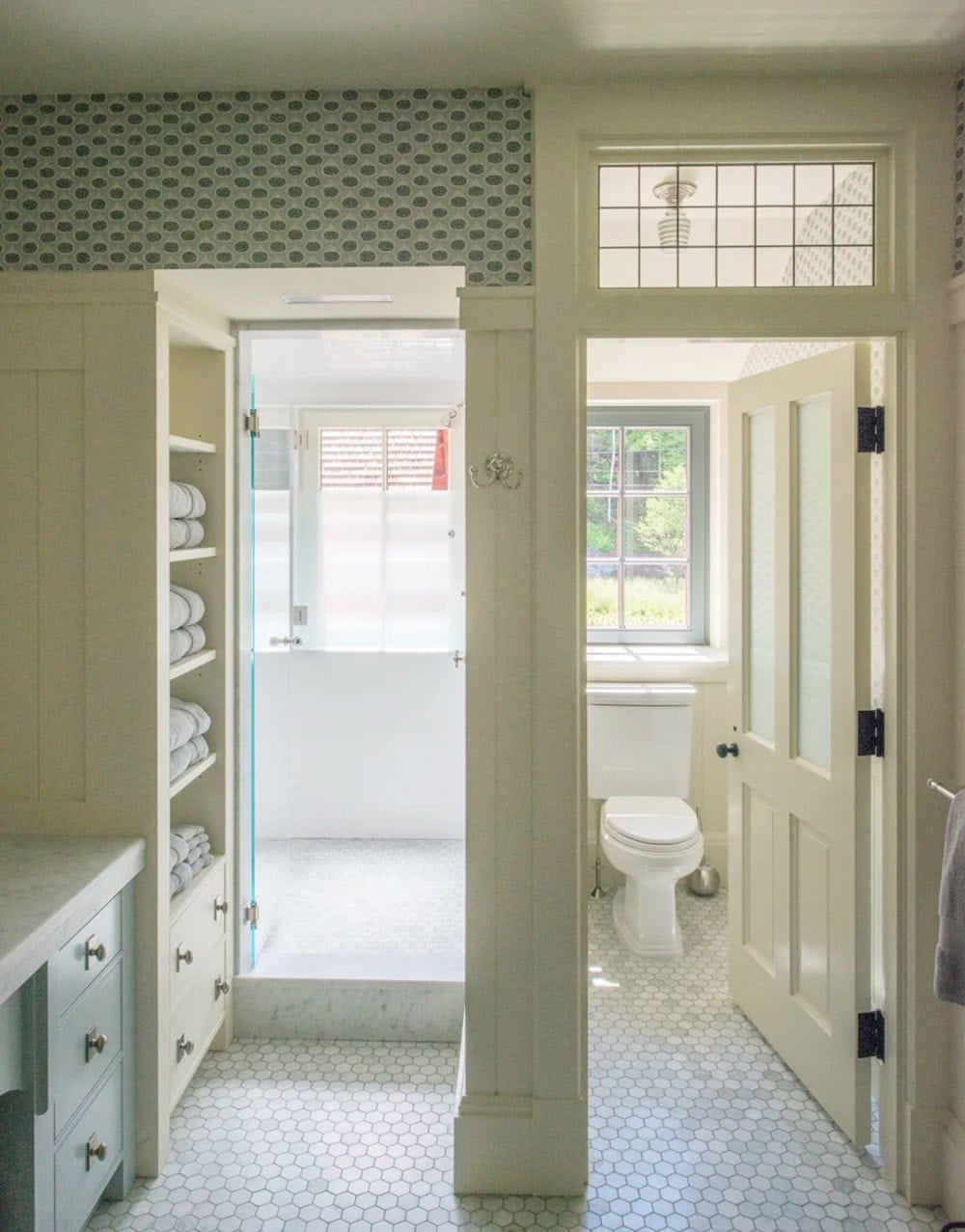 Primary bathroom of the Lake Sunapee New Hampshire lake house with traditional finishes &mdash; painted vanity cabinetry, subway tile, natural stone countertops, and a freestanding claw-foot tub from Apollo